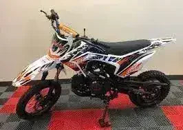 125cc dirt bike with off-road tires and colorful graphics on display indoors