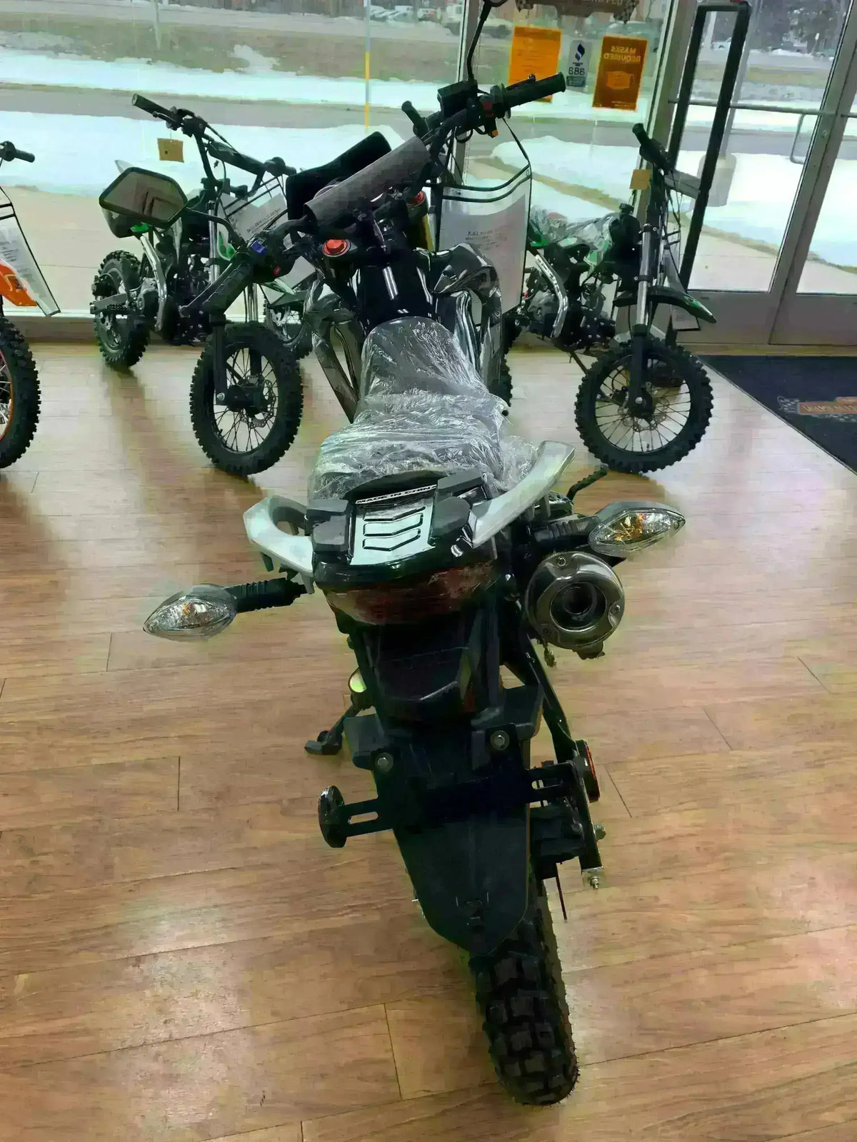 Street-legal Hawk DLX 250 motorcycle on showroom floor with off-road tires.