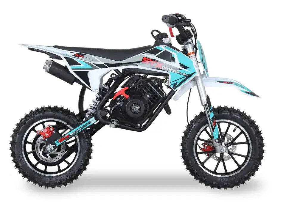 Teal and white mini dirt bike with knobby tires, side view on white background