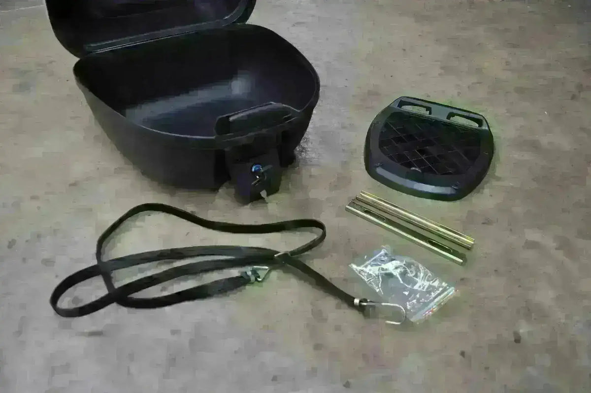 Scooter top case kit with black lockable box, mounting plate, metal rods, strap, and hardware on floor