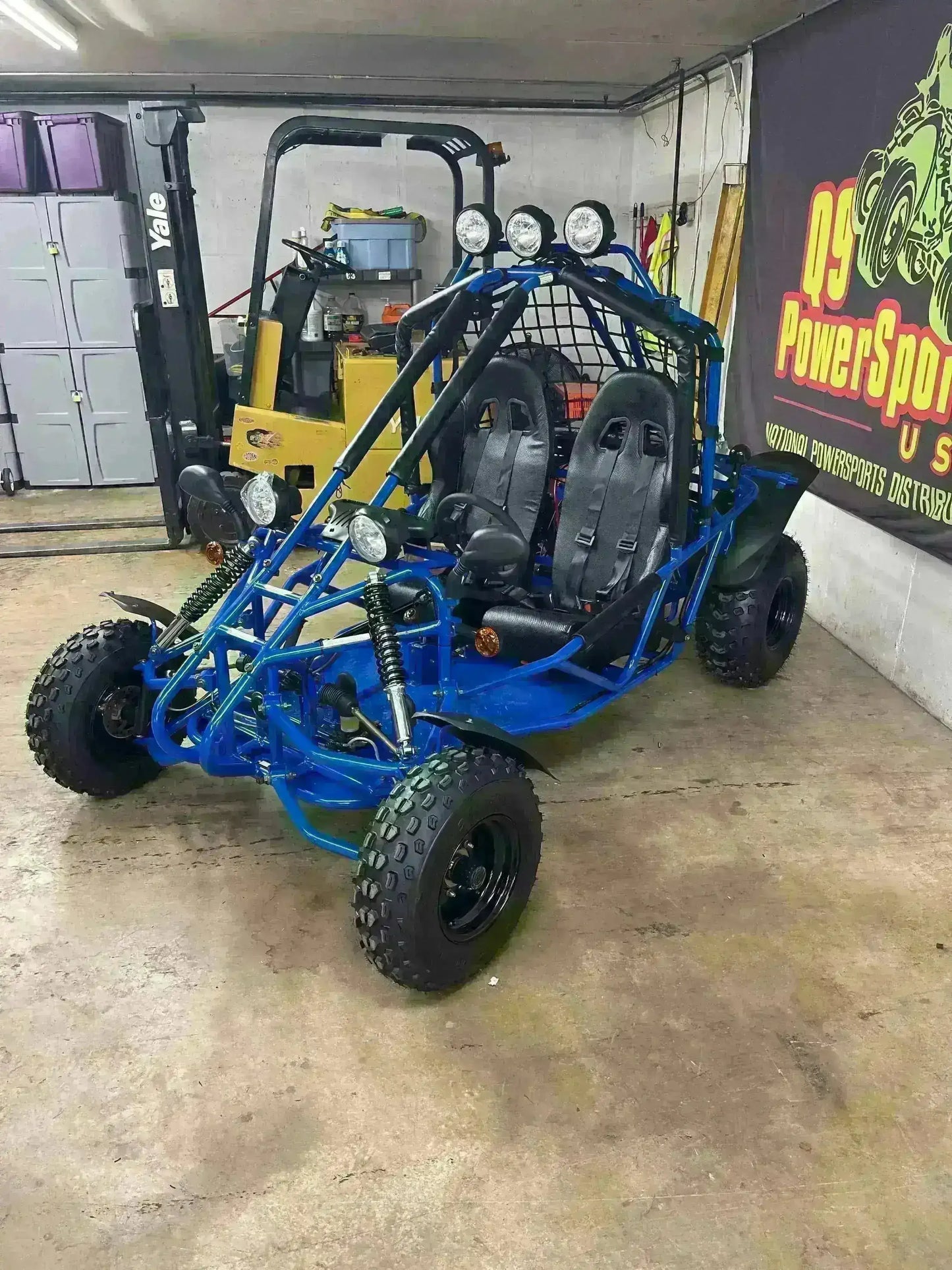 Blue 200cc double seat go-kart with roll cage and off-road tires in a garage setting