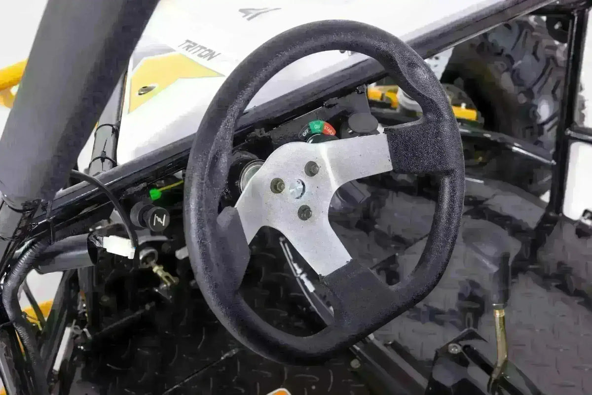 Close-up of the Triton go-kart three-spoke steering wheel, dashboard controls and gear selector