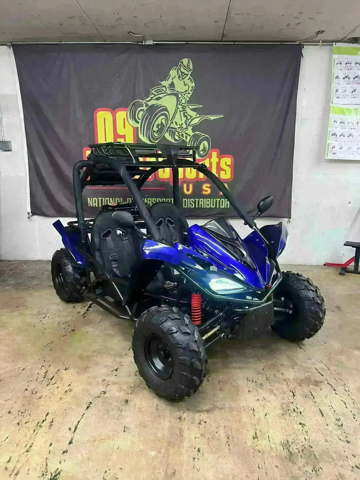Blue 2-seater 125cc go-kart with roll cage and off-road tires in showroom