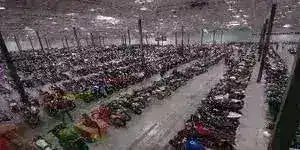 Large warehouse filled with rows of four wheelers, ATVs, and utility vehicles.