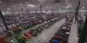 Large warehouse filled with rows of four wheelers, ATVs, and utility vehicles.