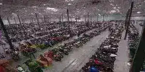 Large warehouse filled with rows of four wheelers, ATVs, and utility vehicles.