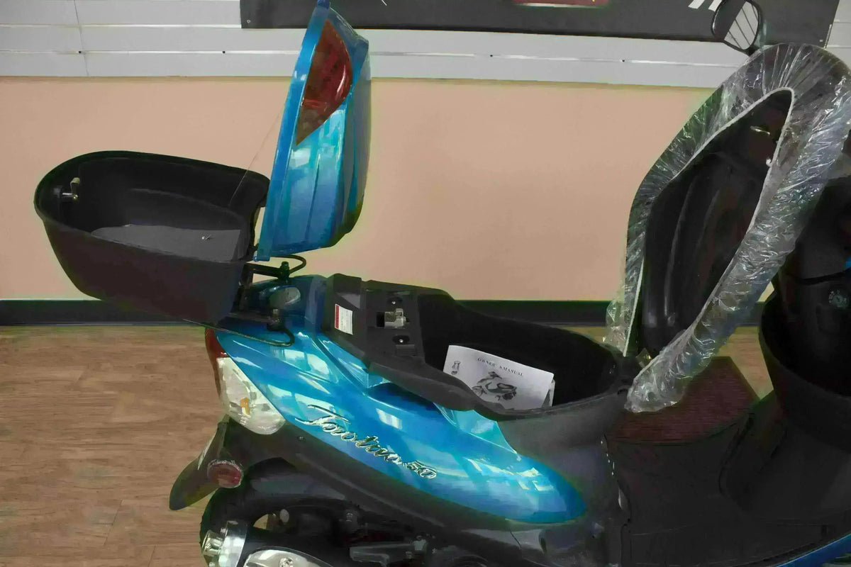 Blue 50cc scooter with open seat and rear storage trunk, showing spacious compartments.