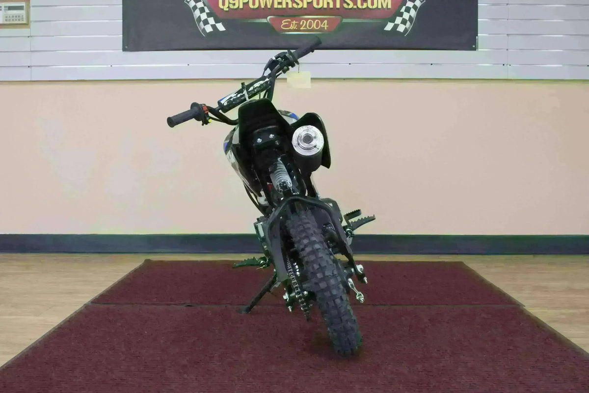 Front view of 110cc kids dirt bike with knobby tires on indoor showroom floor