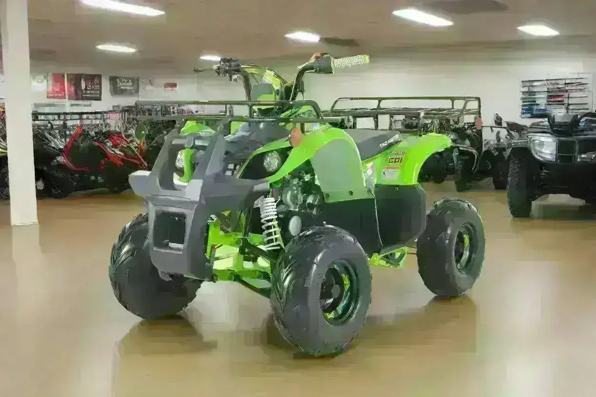 Green 110cc youth utility ATV with rugged tires on showroom floor