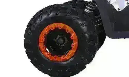 Close-up of an ATV rear wheel with black tread and orange rim on a four-wheeler