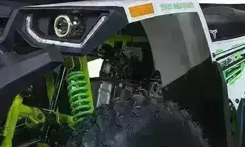 Close-up of a 200cc utility ATV front tire, headlight, and shock absorber