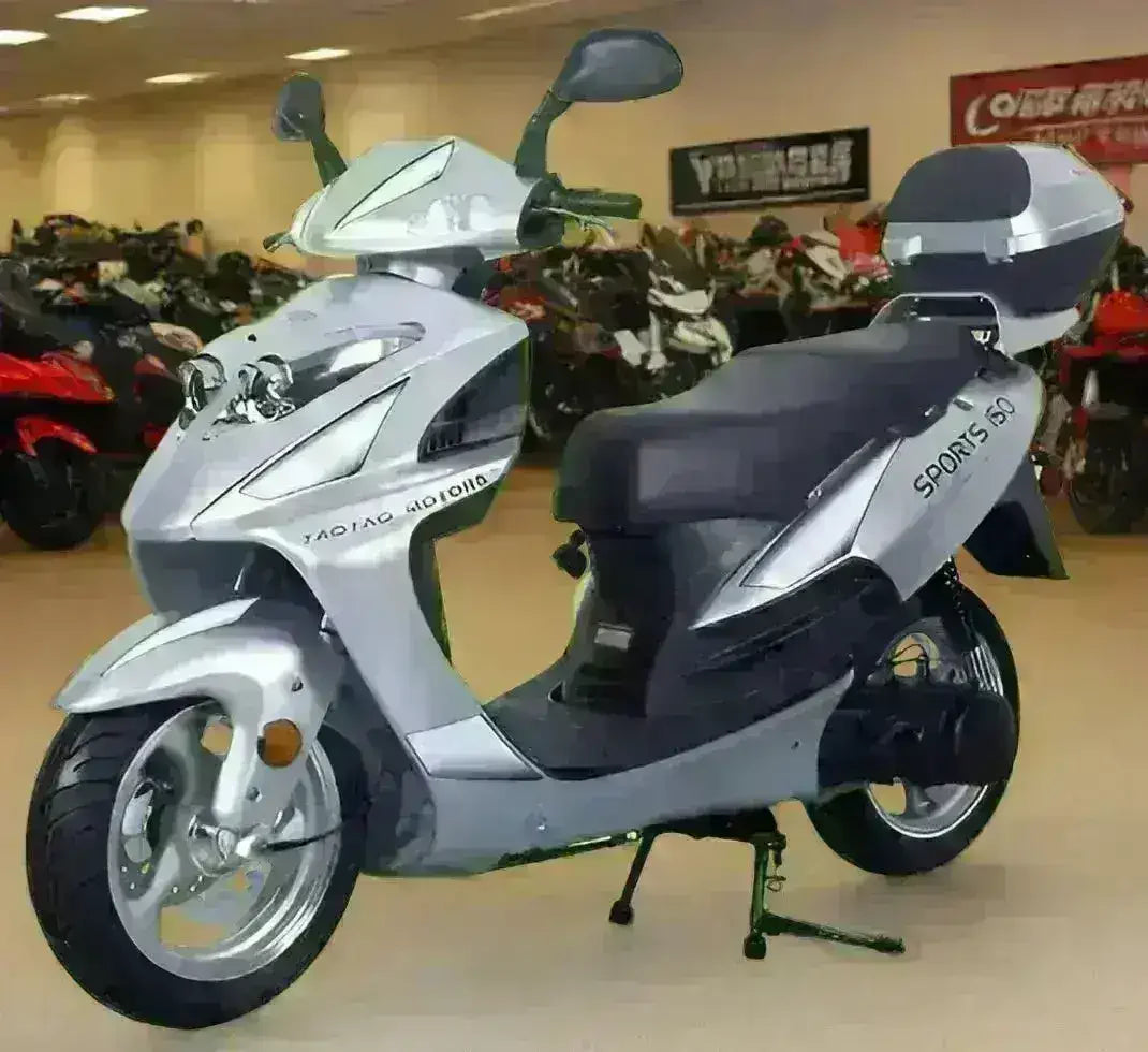 Silver Galaxy 150cc scooter with black seat and rear storage box, front three-quarter view in a showroom