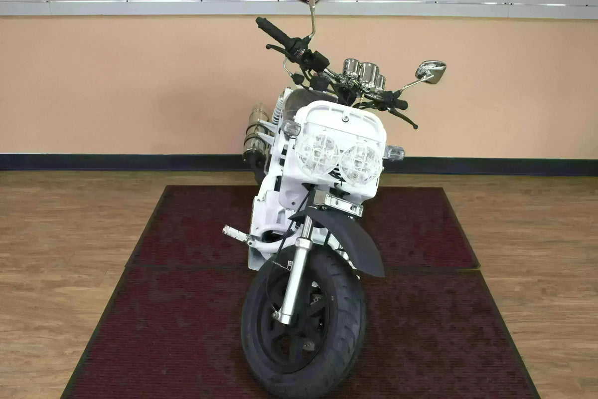 Front view of a white 50cc Maddog scooter with dual headlights on indoor display mat
