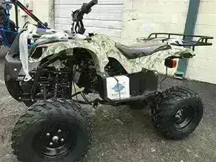 Green camouflage four-wheeler ATV with rugged tires parked outdoors