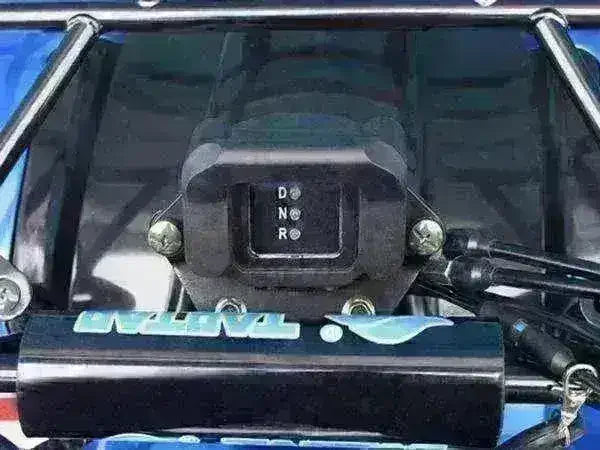 Close-up of gear shift indicator on youth ATV with drive, neutral, and reverse settings.