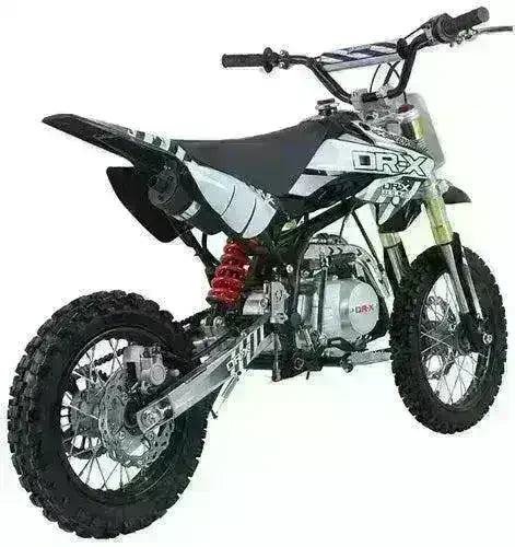 Youth 125cc dirt bike with black and white body, knobby tires, and rear suspension