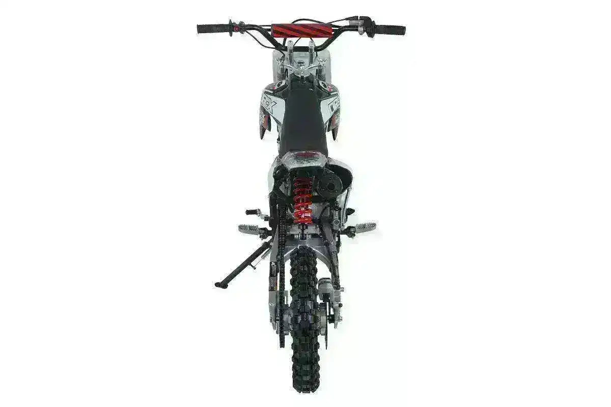 Rear view of 125cc youth dirt bike with knobby tire, black seat, and red suspension