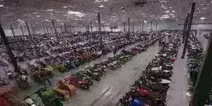 Large warehouse filled with rows of ATVs, dirt bikes, and scooters at Q9 PowerSports USA.