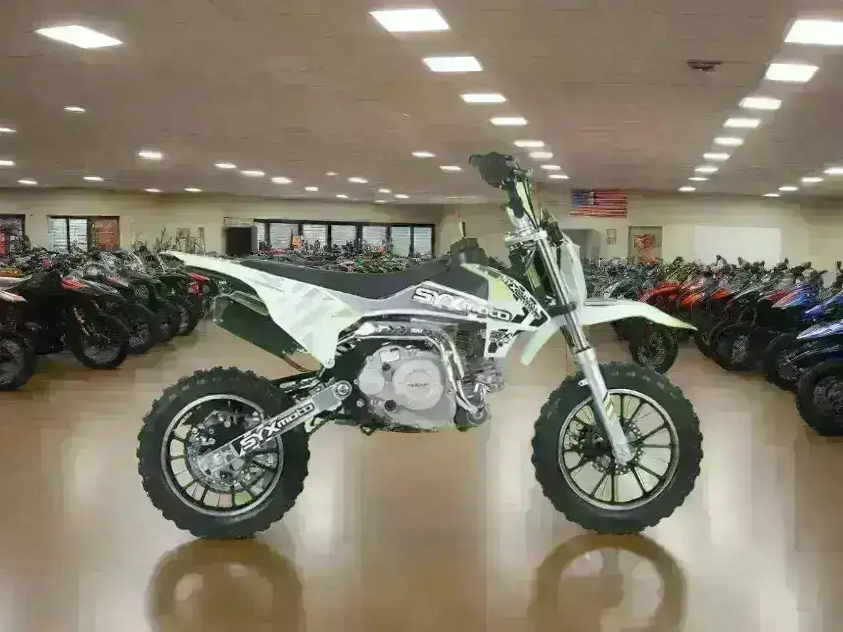 Kids pit bike with knobby tires in a showroom with multiple motorcycles