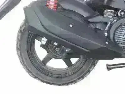 Close-up of rear wheel and suspension on black Vision 150 scooter, white background
