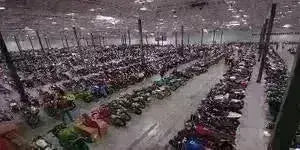 Large indoor warehouse filled with rows of ATVs, scooters, and go-karts for sale