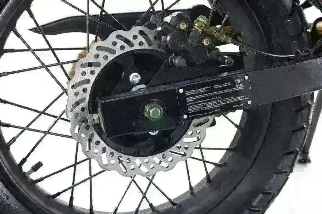 Close-up of motorcycle rear wheel with disc brake and dual sport tire