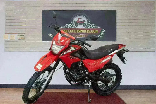 Red Hawk 250cc dirt bike with knobby tires and black seat on showroom floor