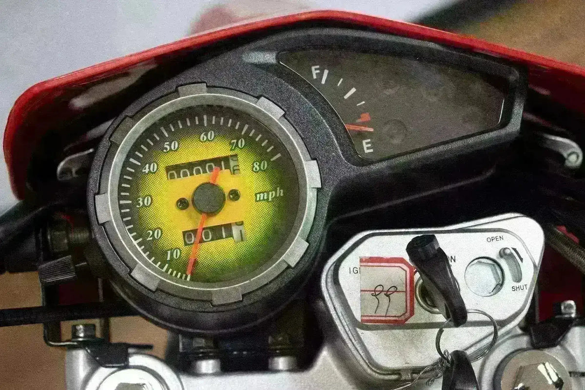 Close-up of a dirt bike dashboard with speedometer, fuel gauge, and ignition key.