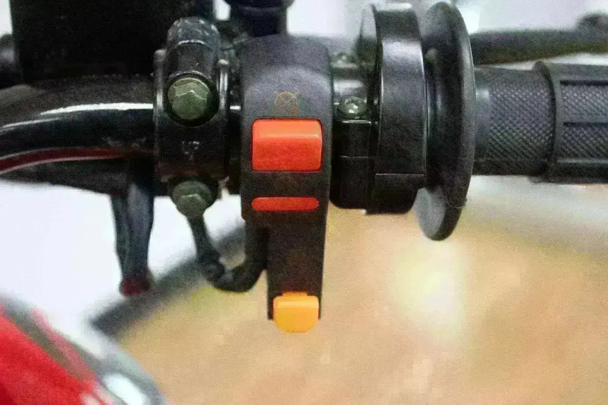Close-up of dirt bike handlebar with control switches and textured grip