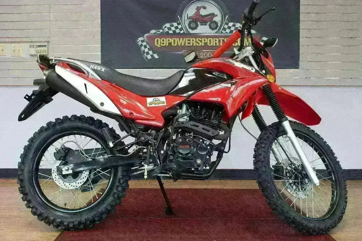 Red Hawk 250cc dirt bike with knobby tires on indoor showroom floor