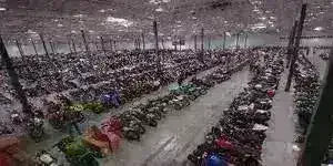 Large warehouse with rows of all-terrain vehicles and dirt bikes on display