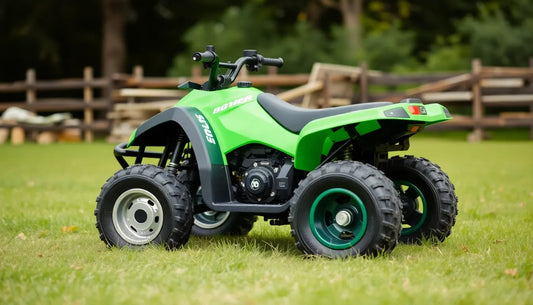 Green youth ATV with rugged tires parked on grass in an outdoor, fenced area