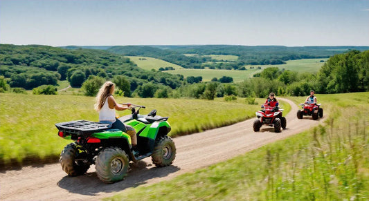 People riding ATVs on a dirt trail through scenic green countryside hills