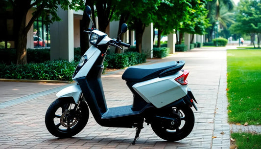 White and black electric scooter parked on a sidewalk surrounded by green trees and grass