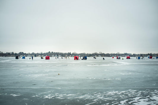 People ice fishing on a frozen lake with colorful ice shanties in winter, southern Wisconsin