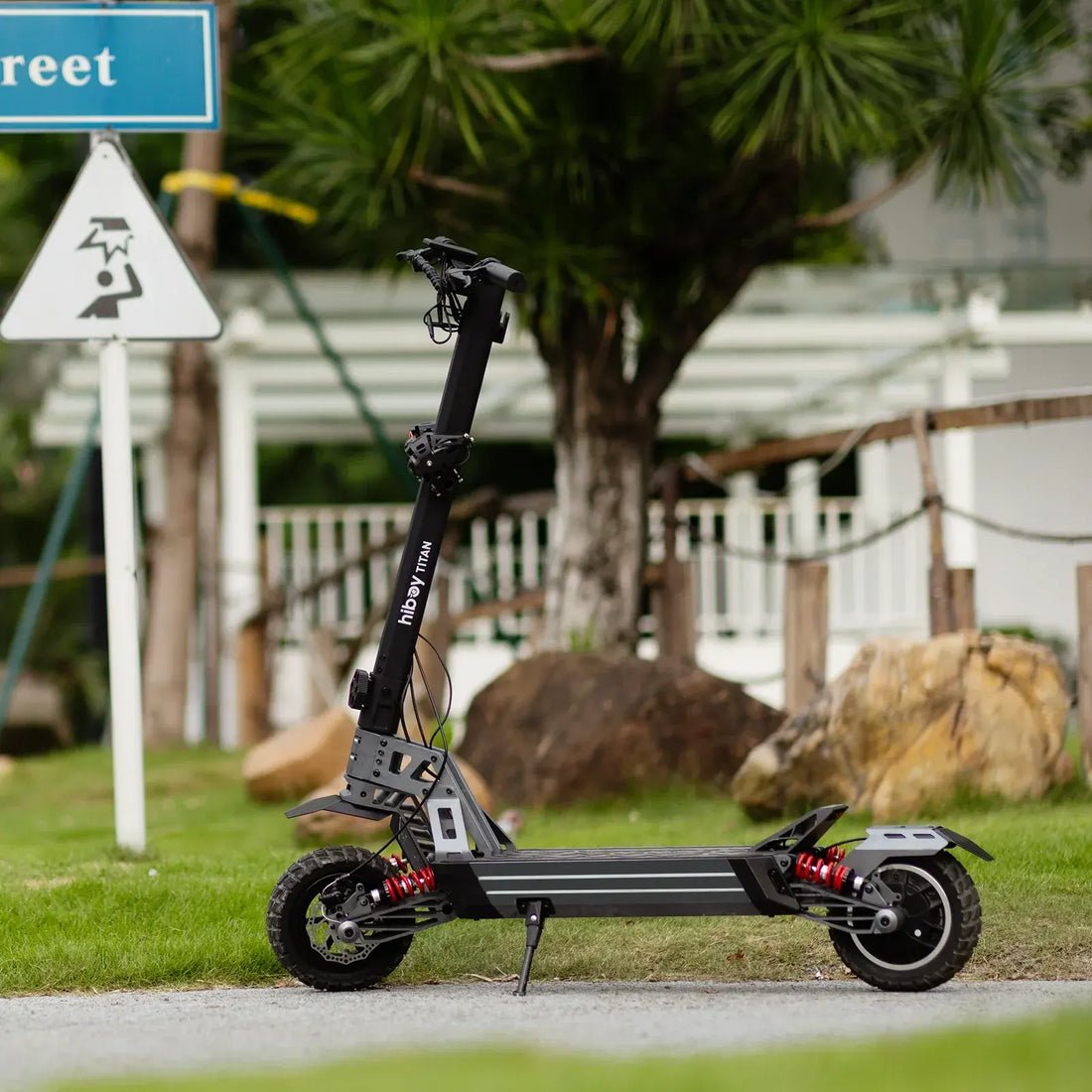 All-terrain electric scooter Hiboy Titan with dual suspension parked outdoors on a path