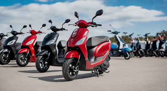 Red and black gas scooters parked outdoors on pavement under a blue sky