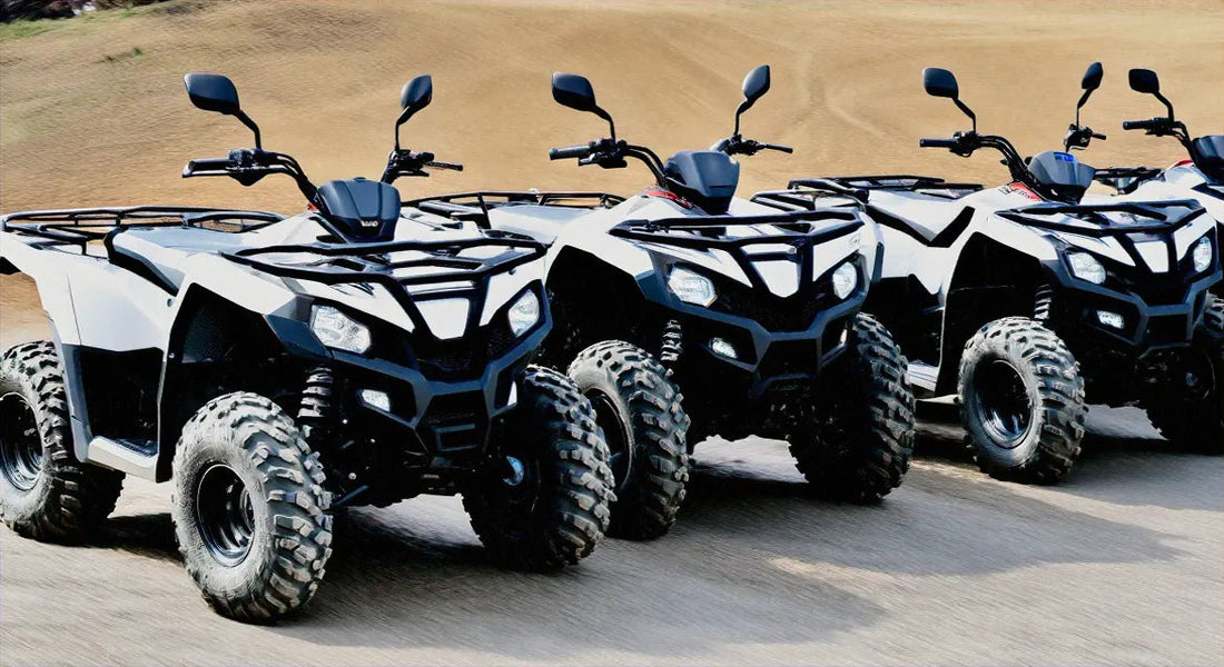 Four all-terrain vehicles lined up on a dirt track, featuring rugged tires and modern design.