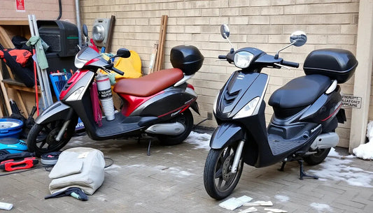 Two parked motor scooters with storage boxes on paved ground by a brick wall, outdoor setting