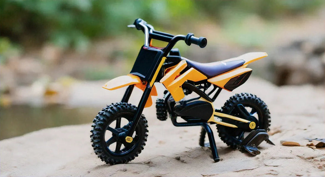Yellow dirt bike with knobby tires parked outdoors on sandy terrain