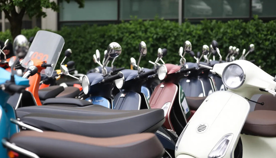 Row of colorful scooters parked outdoors, featuring various models and styles.