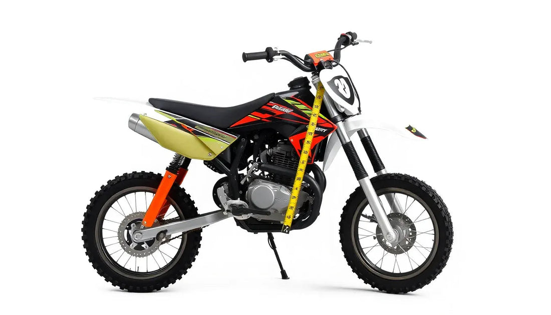 Black and red youth dirt bike with yellow measuring tape along front fork on white background