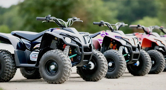 Three youth ATVs with rugged tires parked outdoors on a paved path