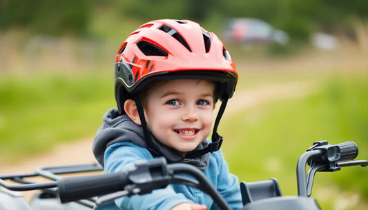 Smiling child in red helmet riding ATV outdoors on a dirt path