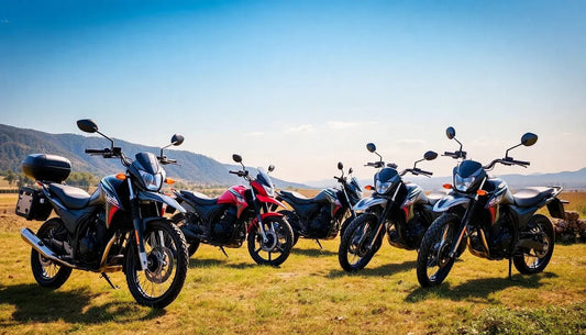Five sport motorcycles parked outdoors on grass, mountains and blue sky in background
