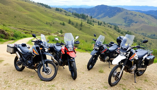 Four adventure dirt bikes with windshields parked on a mountain trail with scenic hills