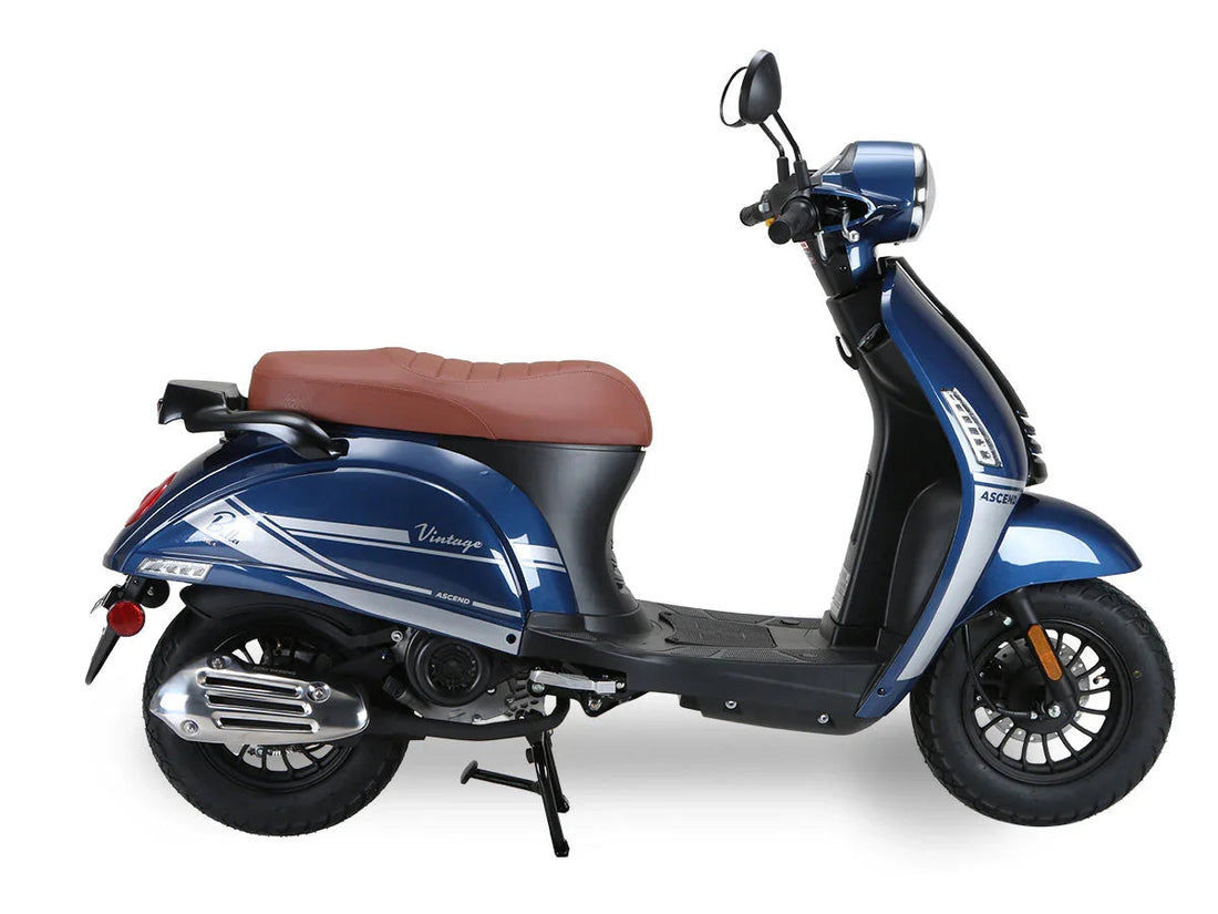 Blue 50cc vintage-style scooter with brown seat and chrome accents on white background