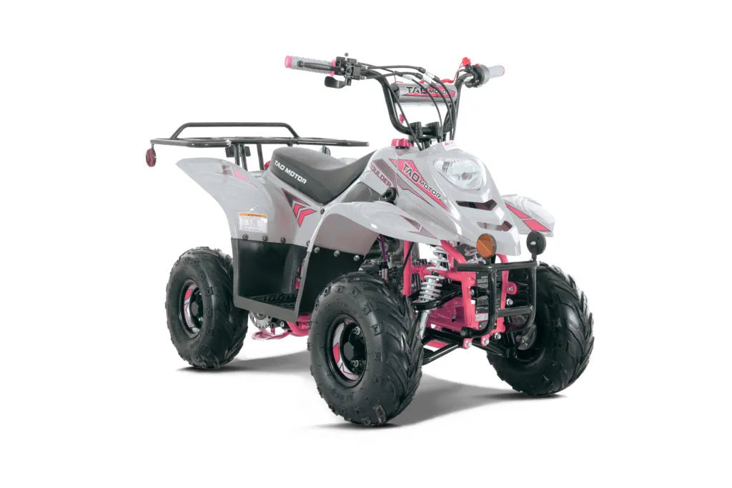 Gray and pink youth ATV with rugged tires and front headlight on white background