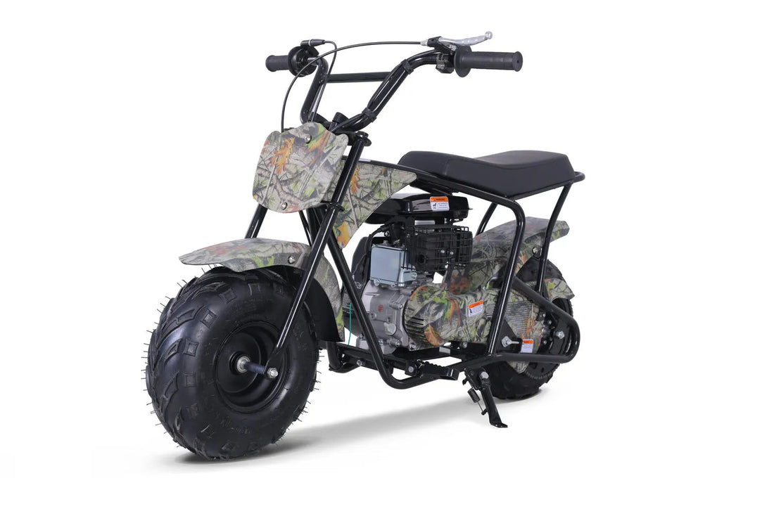 Camo mini bike with large off-road tires and black frame, shown in a studio setting