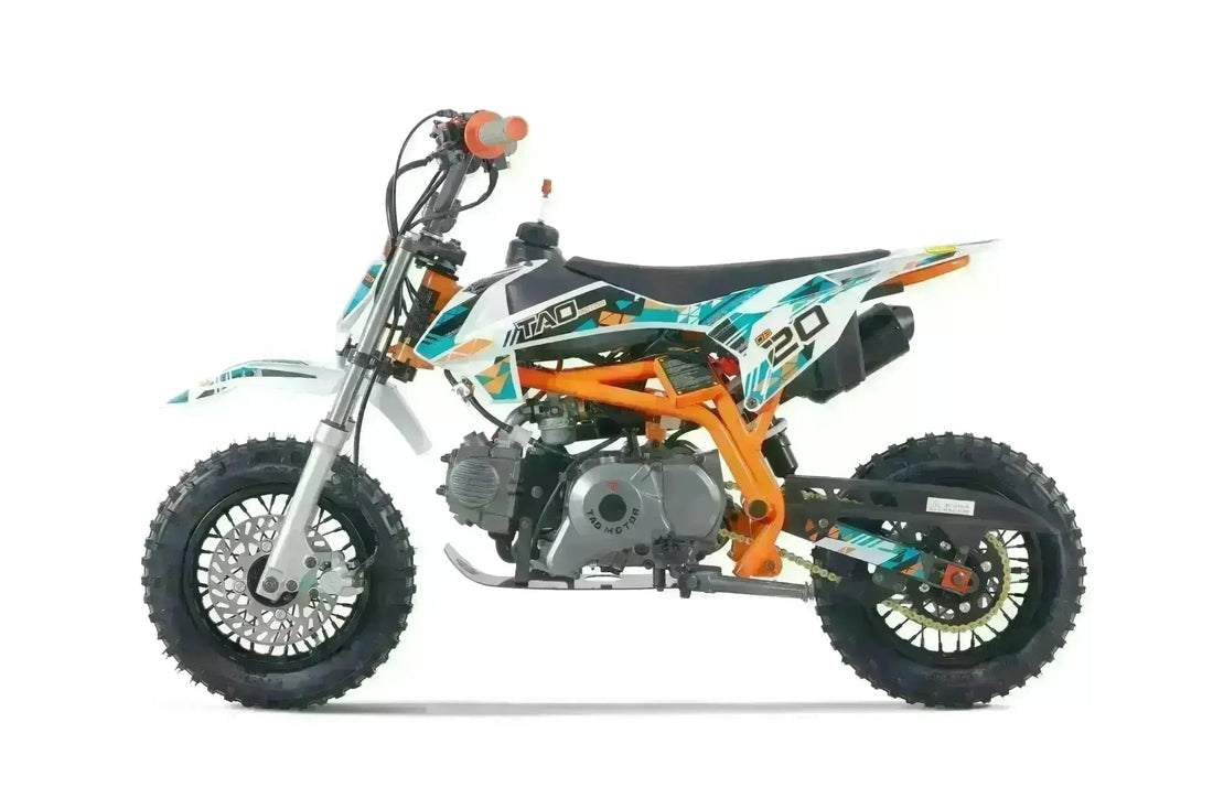 Youth dirt bike with orange frame, knobby tires, and graphic decals on a white background